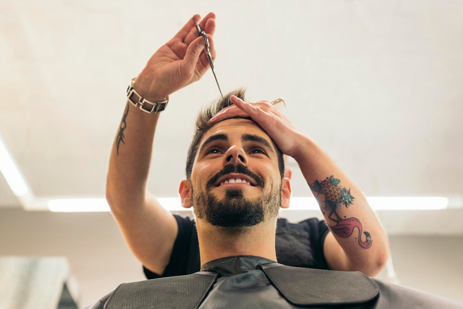 Peluquero realizando corte a cliente con tijeras